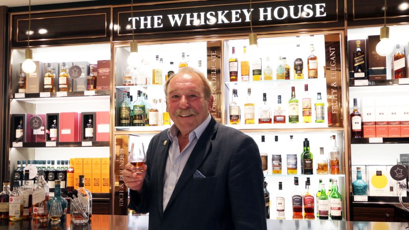 Charles MacLean with a glass of whiskey in front of The Whiskey House